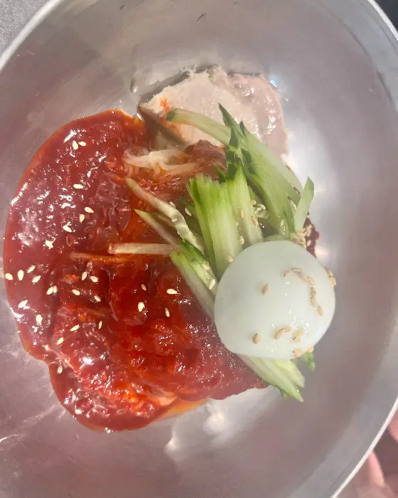 비빔밀면에 곁들여 나온 고기편육. 밀면과 함께 먹으면 더욱 풍성한 맛을 즐길 수 있습니다.