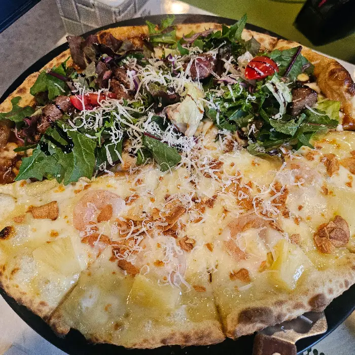 다양한 토핑과 채소가 올라간 피자 사진