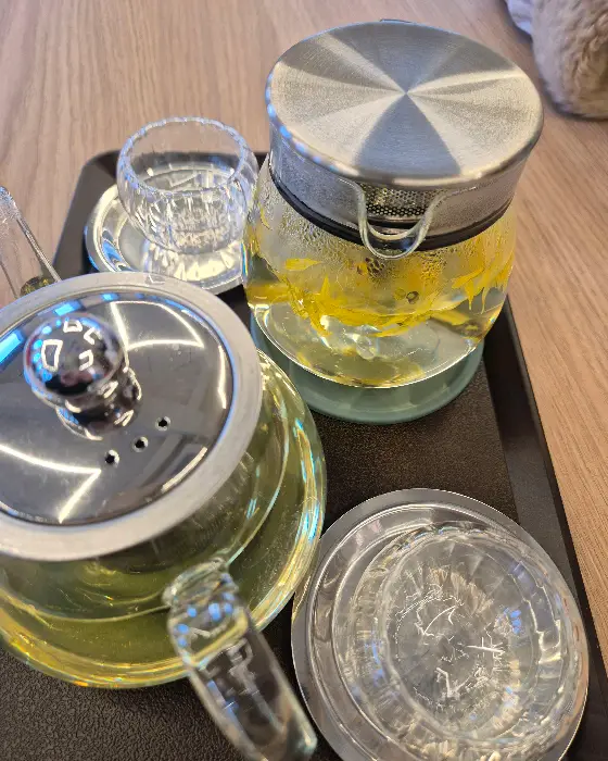 따뜻한 차가 담긴 유리 티포트와 작은 잔