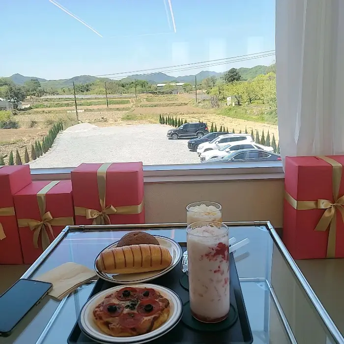 창밖으로 보이는 논밭 풍경과 테이블 위 음식들