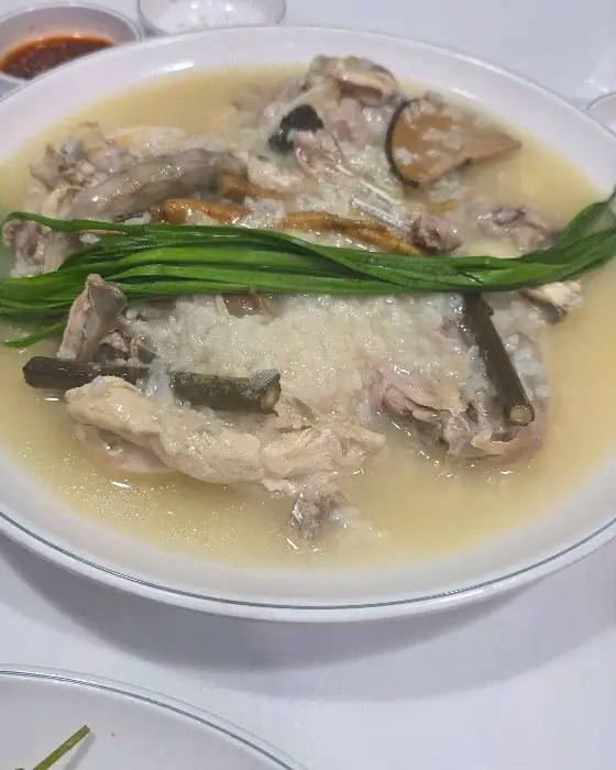 누룽지백숙의 닭고기와 누룽지, 국물이 보이는 근접 사진