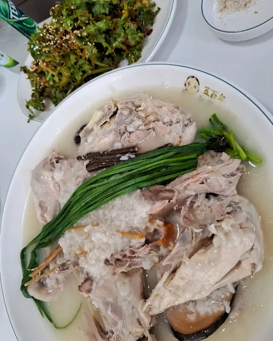 누룽지백숙 위에 올려진 파와 닭고기의 일부, 주변의 반찬들