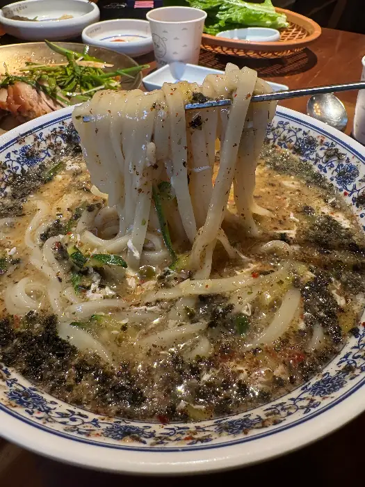칼국수 면발이 젓가락에 걸려 올라온 모습.
