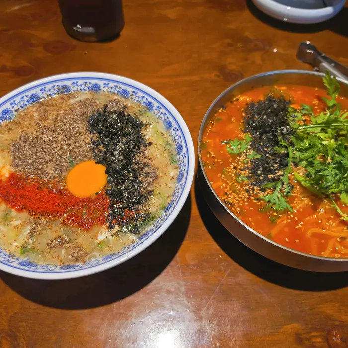 두 그릇의 칼국수와 곁들임 메뉴.