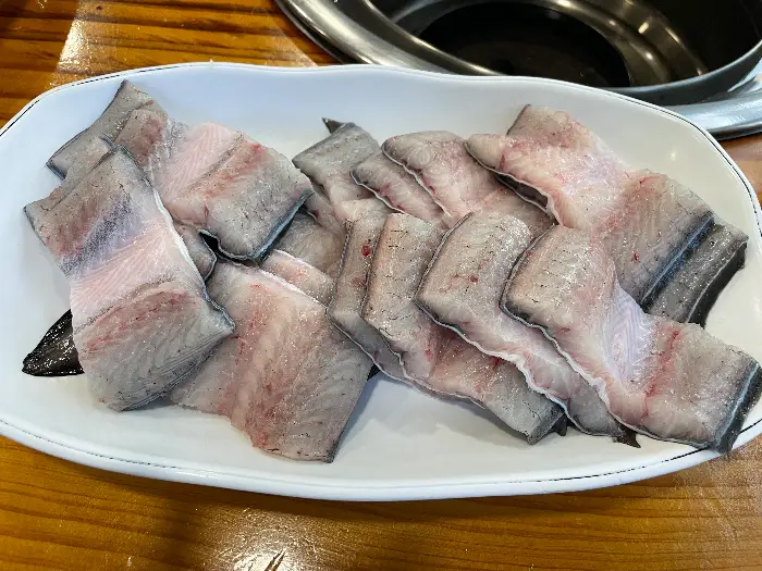 숯불 위에서 익어가는 장어 조각들