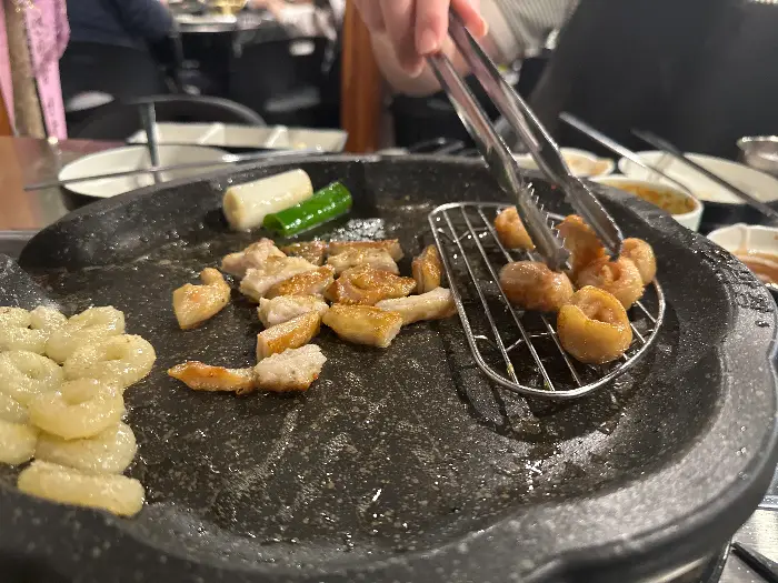 막창을 집게로 집어 뒤집고 있는 모습