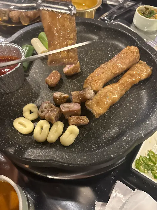 불판 위에서 구워지고 있는 막창과 떡, 파