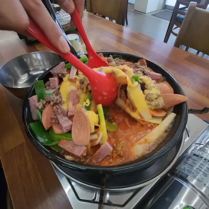치즈가 녹아내리는 부대찌개의 모습. 끓고 있는 국물이 따뜻한 느낌을 줍니다.