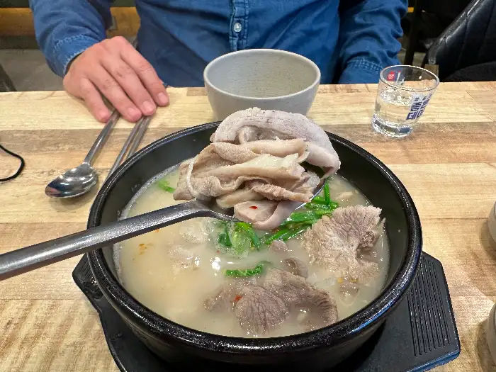 수저로 떠낸 돼지국밥 속의 고기