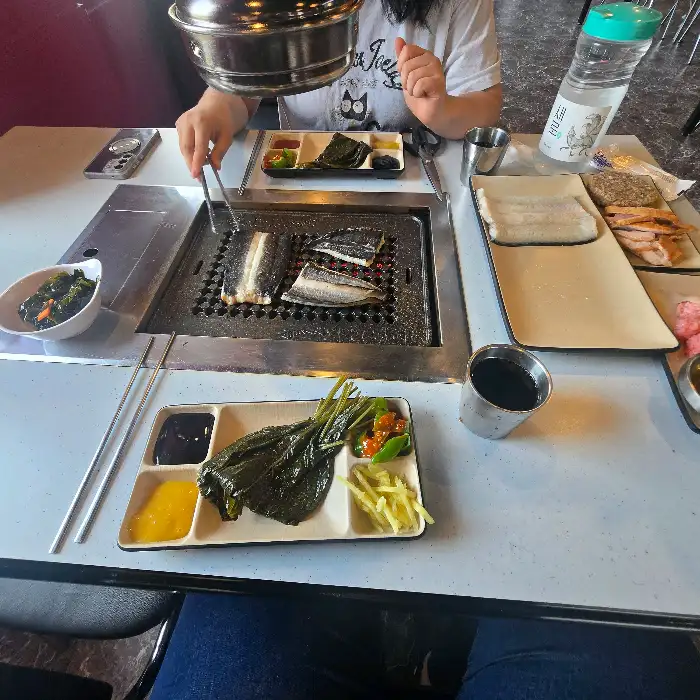 쌈 채소와 함께 장어를 싸 먹는 모습