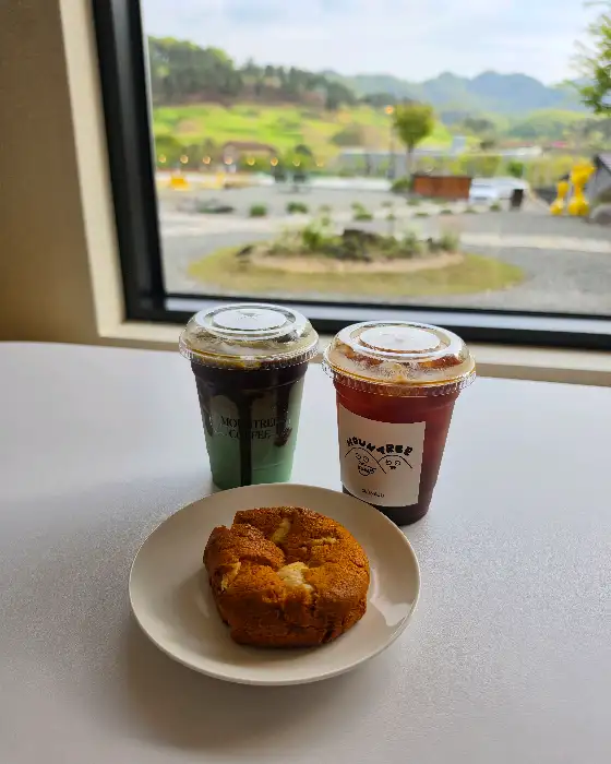 창밖 풍경과 함께 놓인 두 잔의 커피와 빵