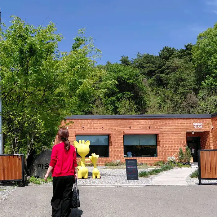 카페 건물 앞에서 사진 찍는 사람