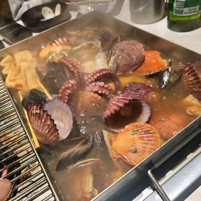 해물찜 찜기 안에서 끓고 있는 다양한 해산물과 채소