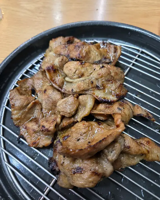 잘 구워진 숯불고기가 철망 위에 놓여 있다.