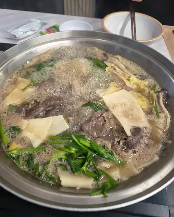 샤브샤브 냄비 안에서 고기와 채소가 익어가며 김이 나는 모습