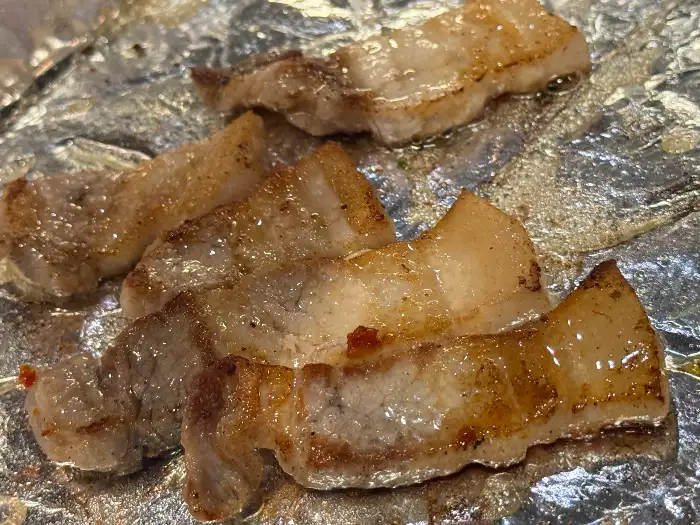 불판 위에서 맛있게 구워지고 있는 냉동 삼겹살