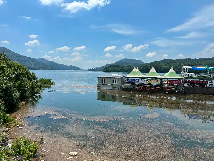 장성호의 넓은 수면과 푸른 하늘, 그리고 호수 주변의 산이 보인다.