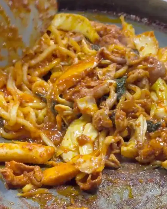 철판 위에서 볶아지고 있는 닭갈비와 우동사리의 모습