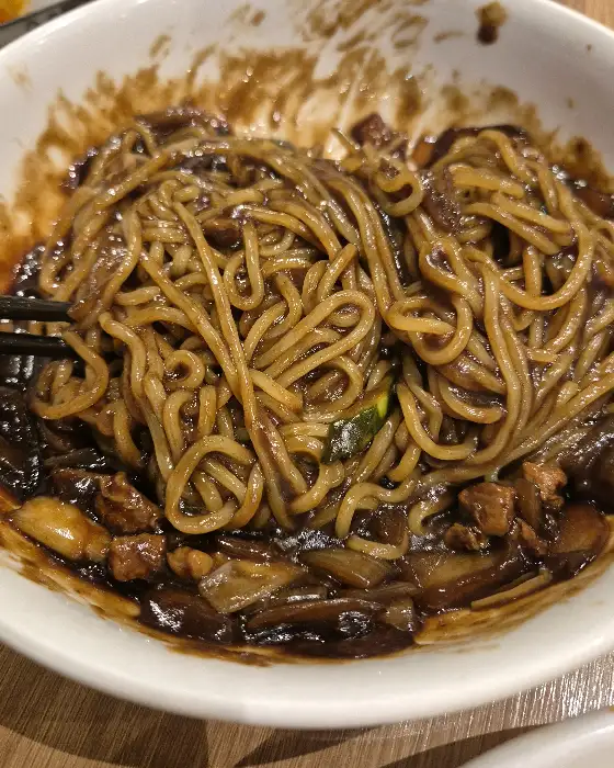 짜장 소스와 볶음밥이 함께 담겨 있습니다.