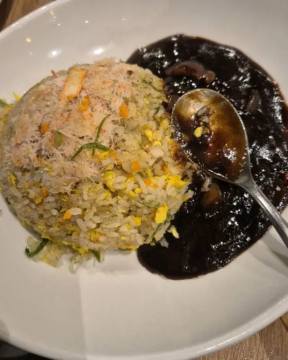 고슬고슬하게 볶아진 볶음밥 위에 짜장 소스가 곁들여져 있습니다.