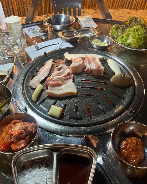 숯불 위에서 익어가는 삼겹살과 항정살