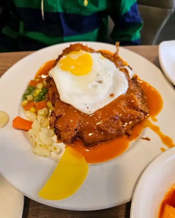 돈까스 위에 계란 프라이와 소스가 얹어진 모습