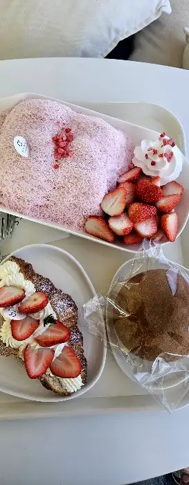 핑크색 빙수와 딸기가 곁들여진 디저트, 그리고 브라우니가 접시에 담겨 있습니다.