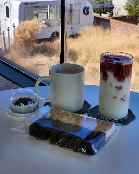 창밖으로 보이는 풍경과 함께 테이블 위에 놓인 음료와 디저트