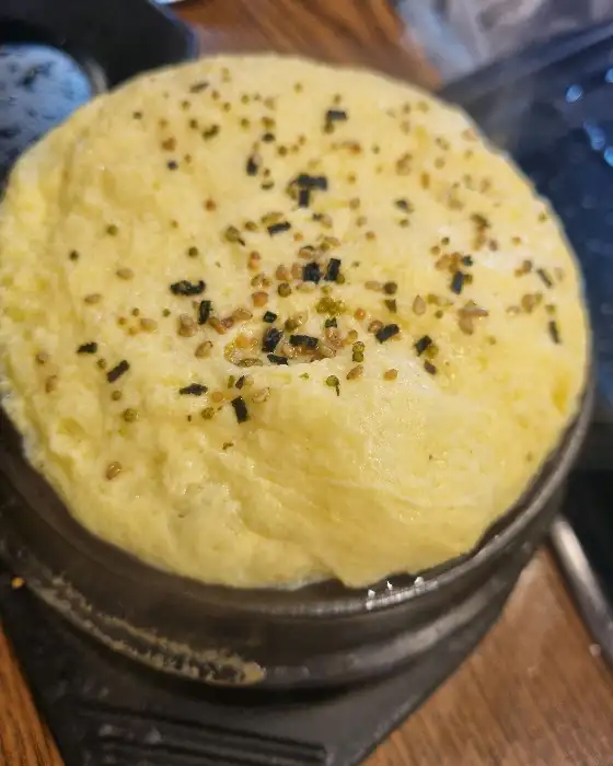 노릇하게 익은 계란찜에 김가루와 깨가 뿌려져 있는 모습