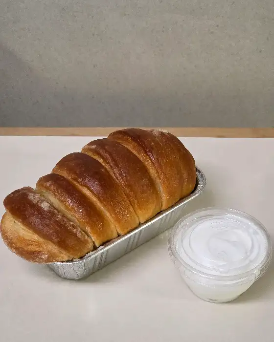 알루미늄 트레이에 담겨 잘린 버터모닝과 작은 용기에 담긴 하얀 크림