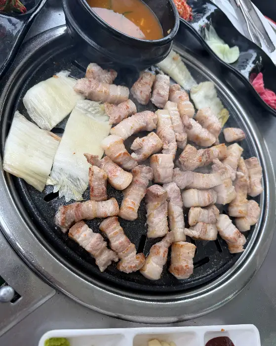 불판 위에서 노릇하게 익어가는 삼겹살