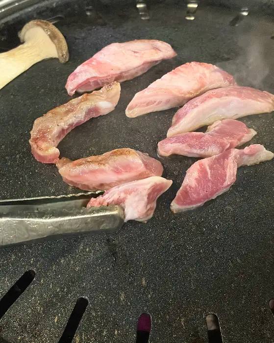 불판 위에서 익고 있는 목살과 버섯