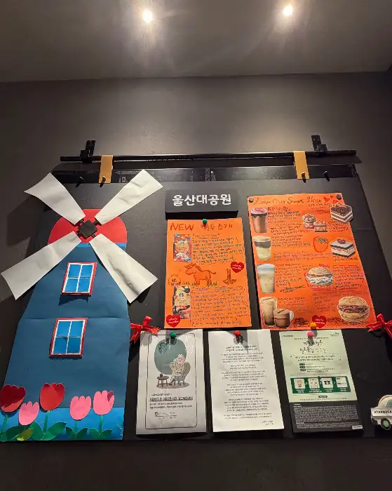 풍차와 벚꽃, 그리고 각종 음료와 디저트 사진이 붙어있는 홍보 보드
