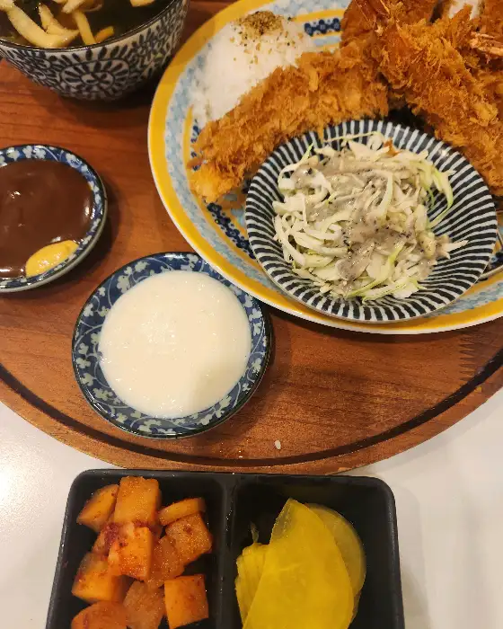 돈까스와 곁들임 반찬, 그리고 소스가 담긴 사진