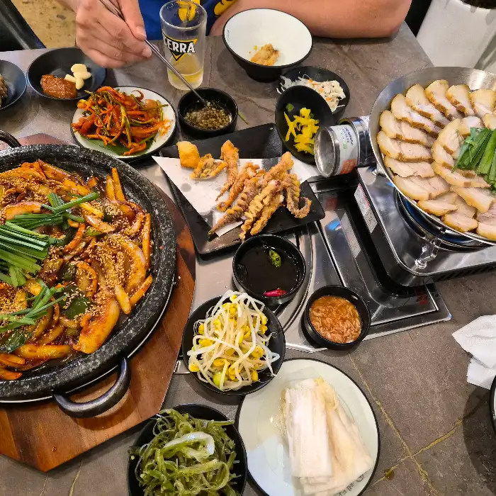 푸짐하게 차려진 한상차림 (돌판 오징어, 수육, 튀김 등)