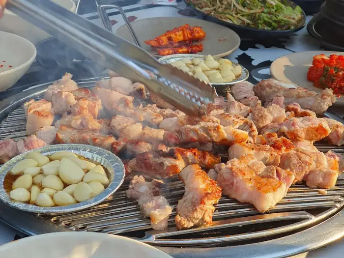 다양한 고기 부위가 불판에 올라가 있는 모습