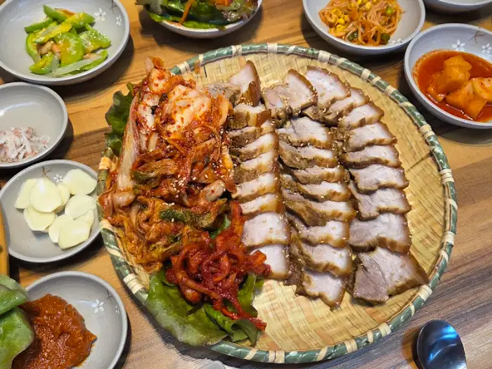 윤기가 자르르 흐르는 보쌈 한 점과 새빨간 양념의 김치가 시선을 사로잡는 모습