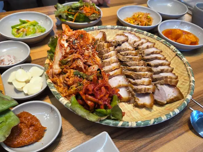 보쌈 위에 얹어진 김치와 곁들여 먹을 수 있는 다양한 소스들