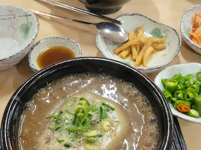 접짝뼈국 국물 위에 얇게 썬 파채가 얹어져 있는 클로즈업 사진.