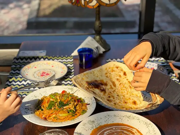 식탁 위에 놓인 커리와 난, 볶음면