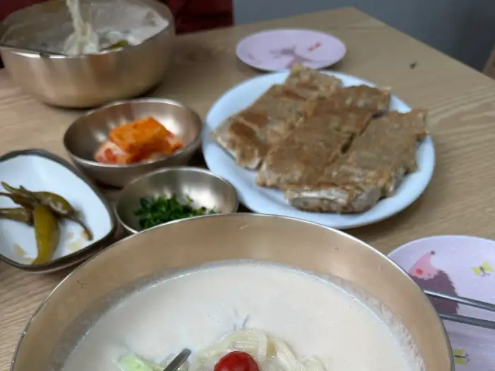 홍두깨국시 식탁 전체 모습, 콩국수와 여러 밑반찬이 보입니다.