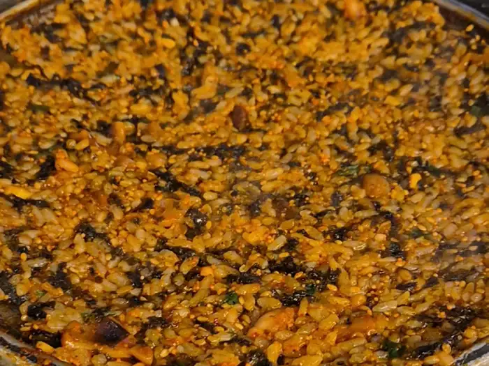 신선한 깻잎 위에 쌈무, 쭈삼, 천사채, 날치알을 얹어 싸 먹는 모습.