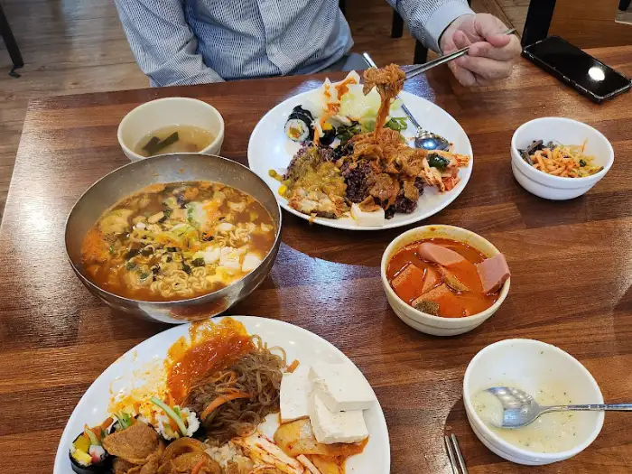 여러 사람이 함께 식사하며 다양한 음식을 맛보는 모습