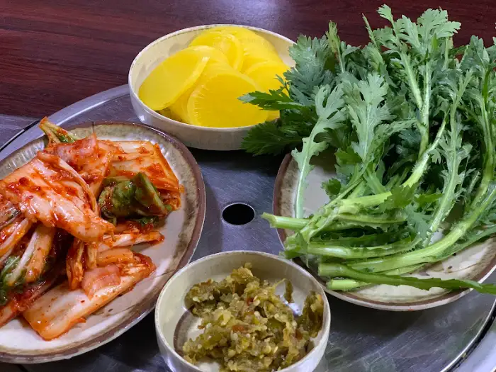 단무지, 겉절이, 쑥갓이 담긴 그릇들