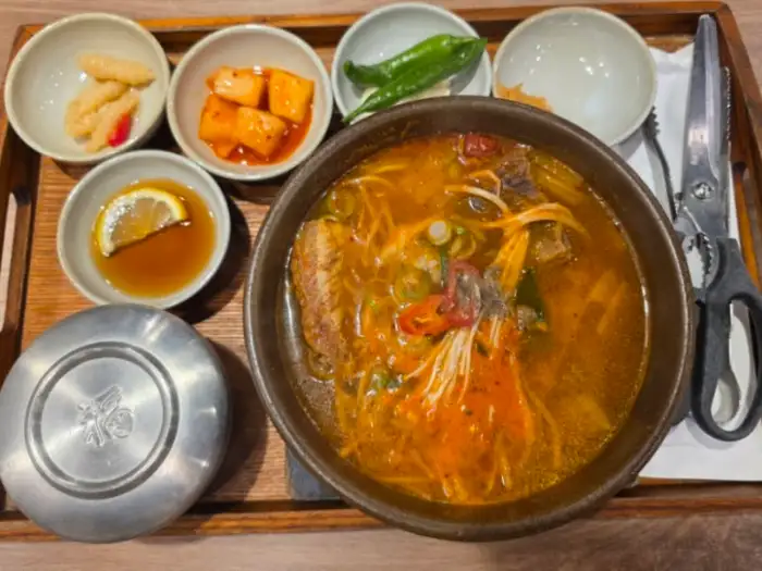 얼큰한 국물의 갈비탕 위에 고추 슬라이스가 올라가 있는 모습