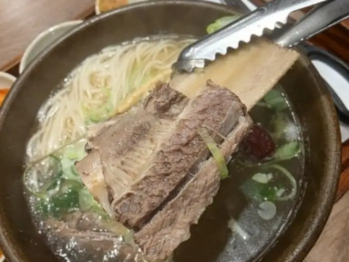 갈비탕 국물에 쫄깃한 중면이 듬뿍 담겨 있는 모습