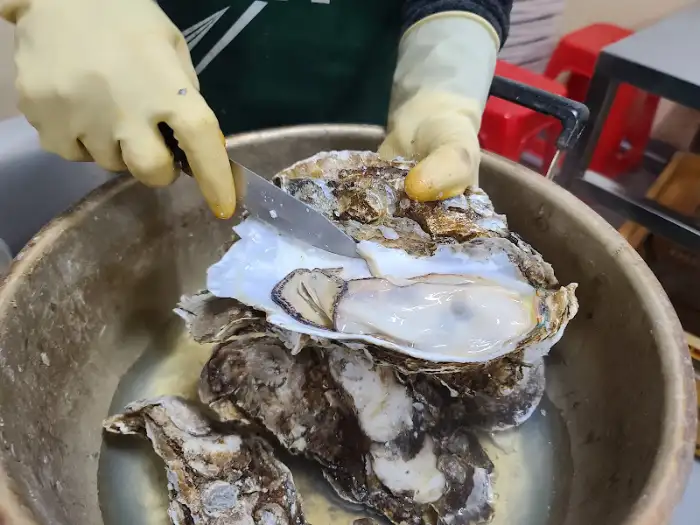 손으로 굴 껍질을 따는 모습