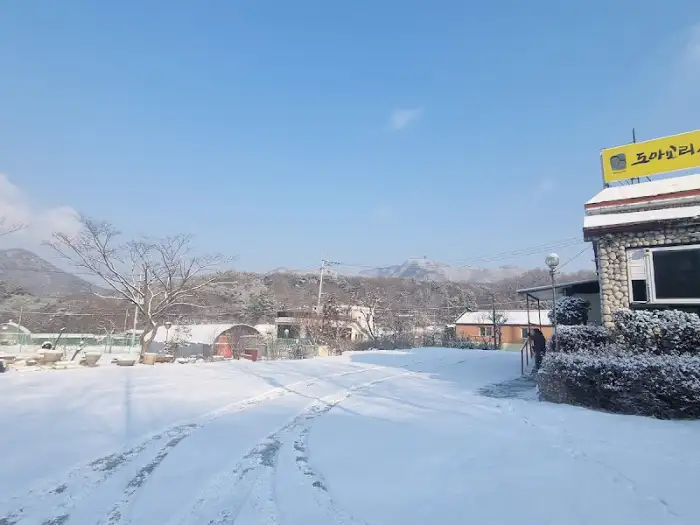 눈 쌓인 도로와 도토리 시골집 간판