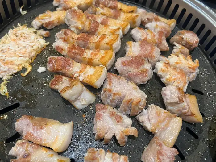 숙련된 솜씨로 삼겹살을 굽고 있는 모습