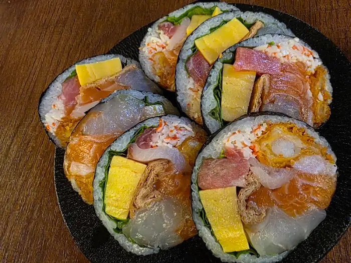 김밥처럼 말아진 롤에 다양한 속재료가 겹겹이 쌓여 있는 모습